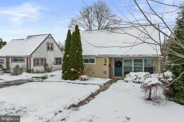 a front view of a house with a yard covered with snow in front of house