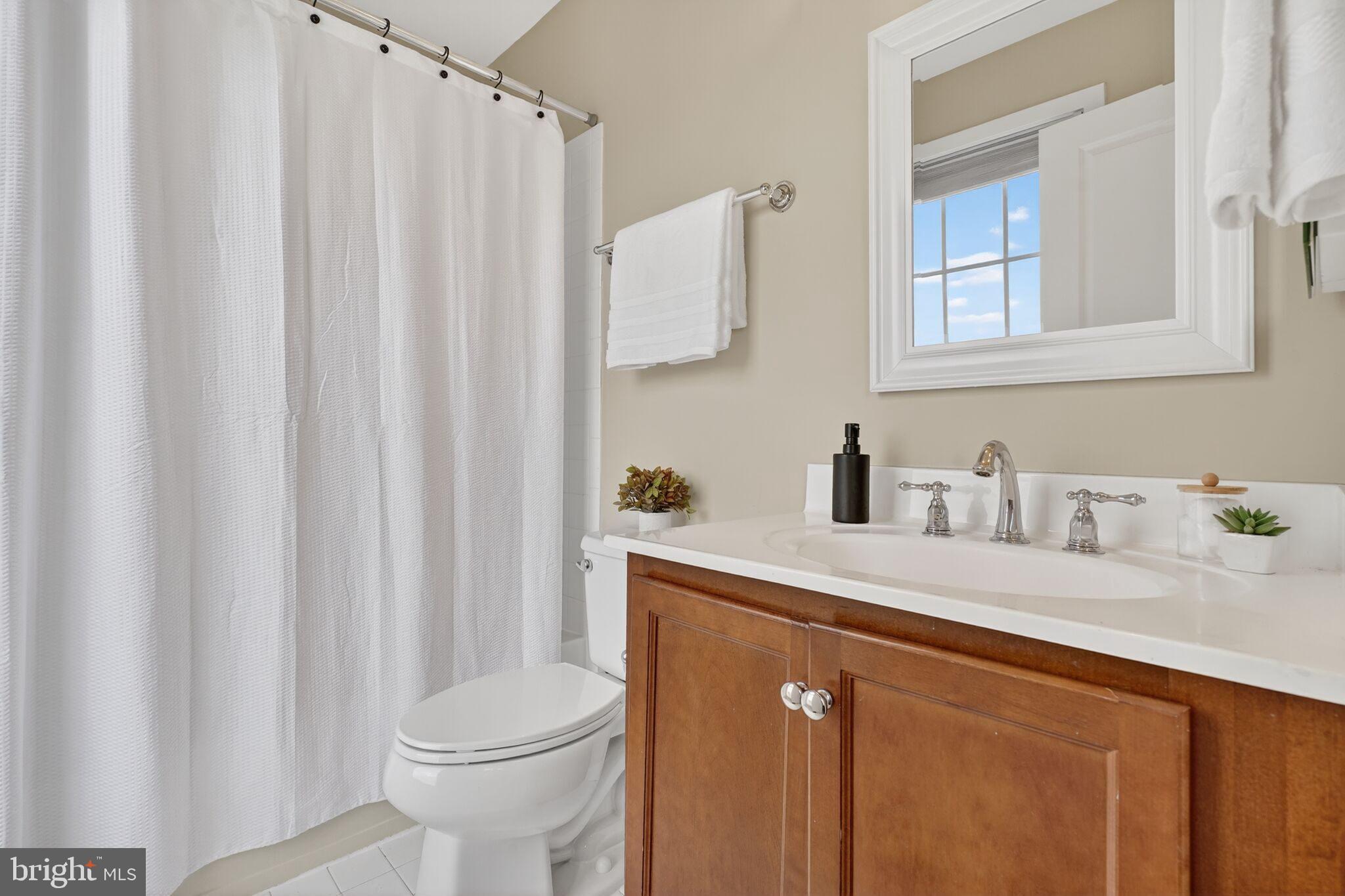 2909 Chancellor's Way Northeast Washington, DC 20017 - Photo 24 of 31 a bathroom with a sink a toilet and a mirror