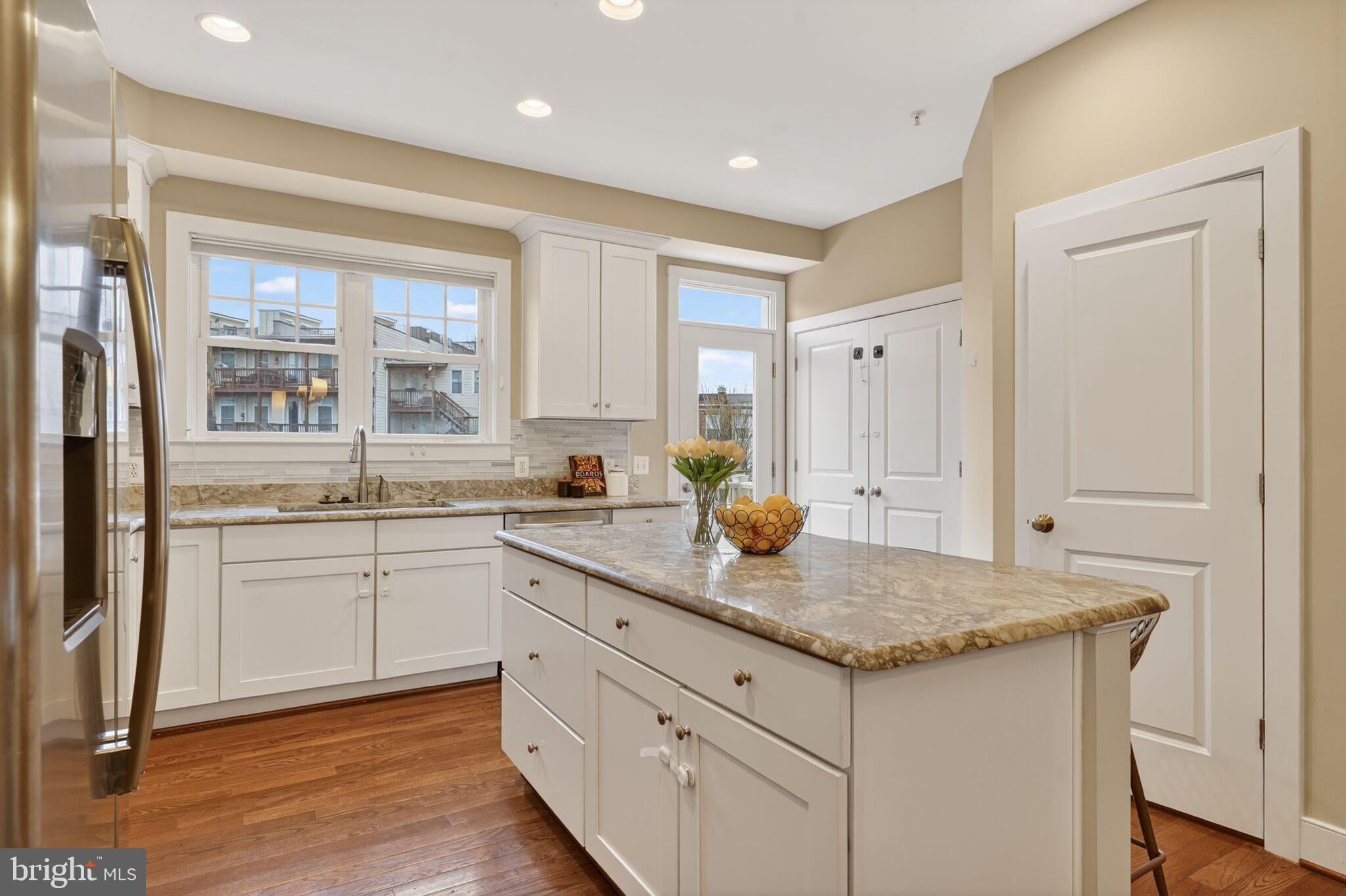2909 Chancellor's Way Northeast Washington, DC 20017 - Photo 6 of 31 a kitchen with granite countertop white cabinets and a window