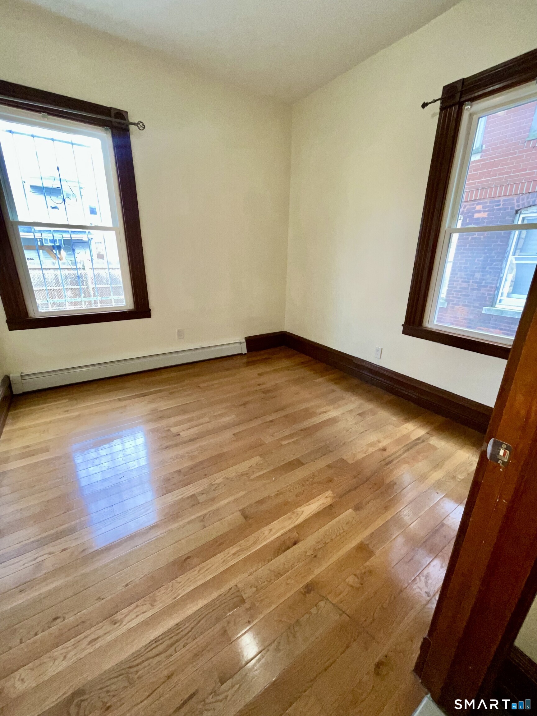 Undisclosed Address Bridgeport, CT 06608 - Photo 3 of 10 a view of an empty room with wooden floor and a window