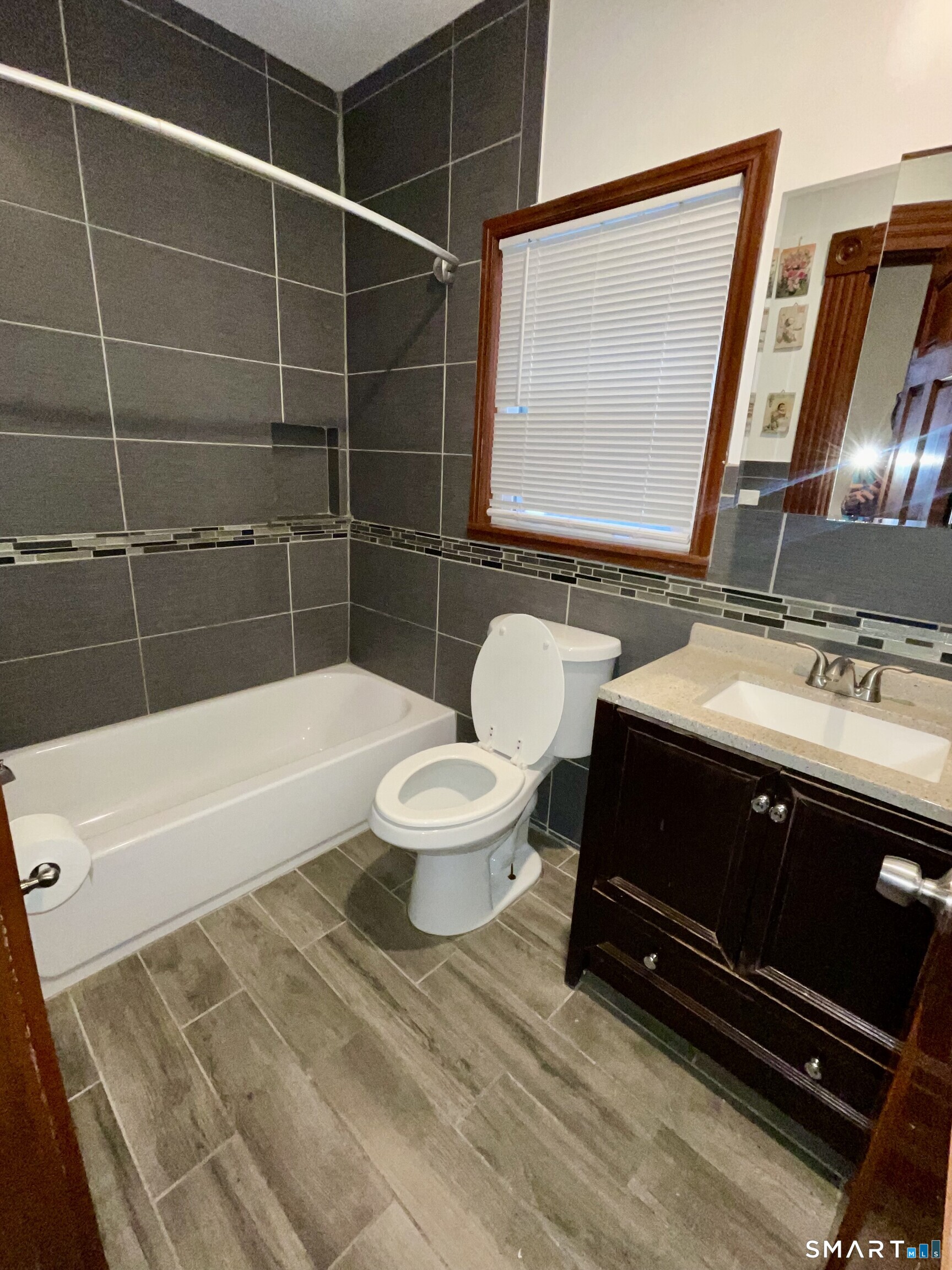 Undisclosed Address Bridgeport, CT 06608 - Photo 9 of 10 a bathroom with a sink a toilet a mirror and bathtub