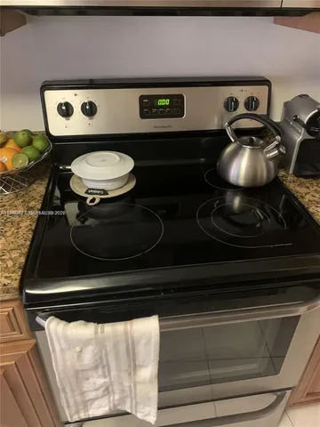 a kitchen with stainless steel appliances kitchen island granite countertop a sink and a white cabinets
