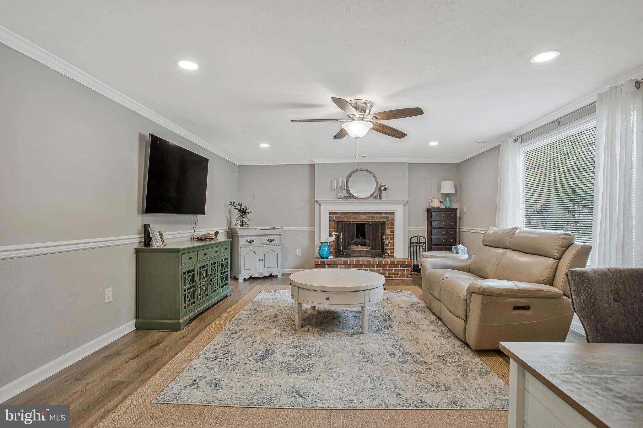 114 River Road Edgewater, MD 21037 - Photo 9 of 30 a living room with furniture a fireplace and a flat screen tv