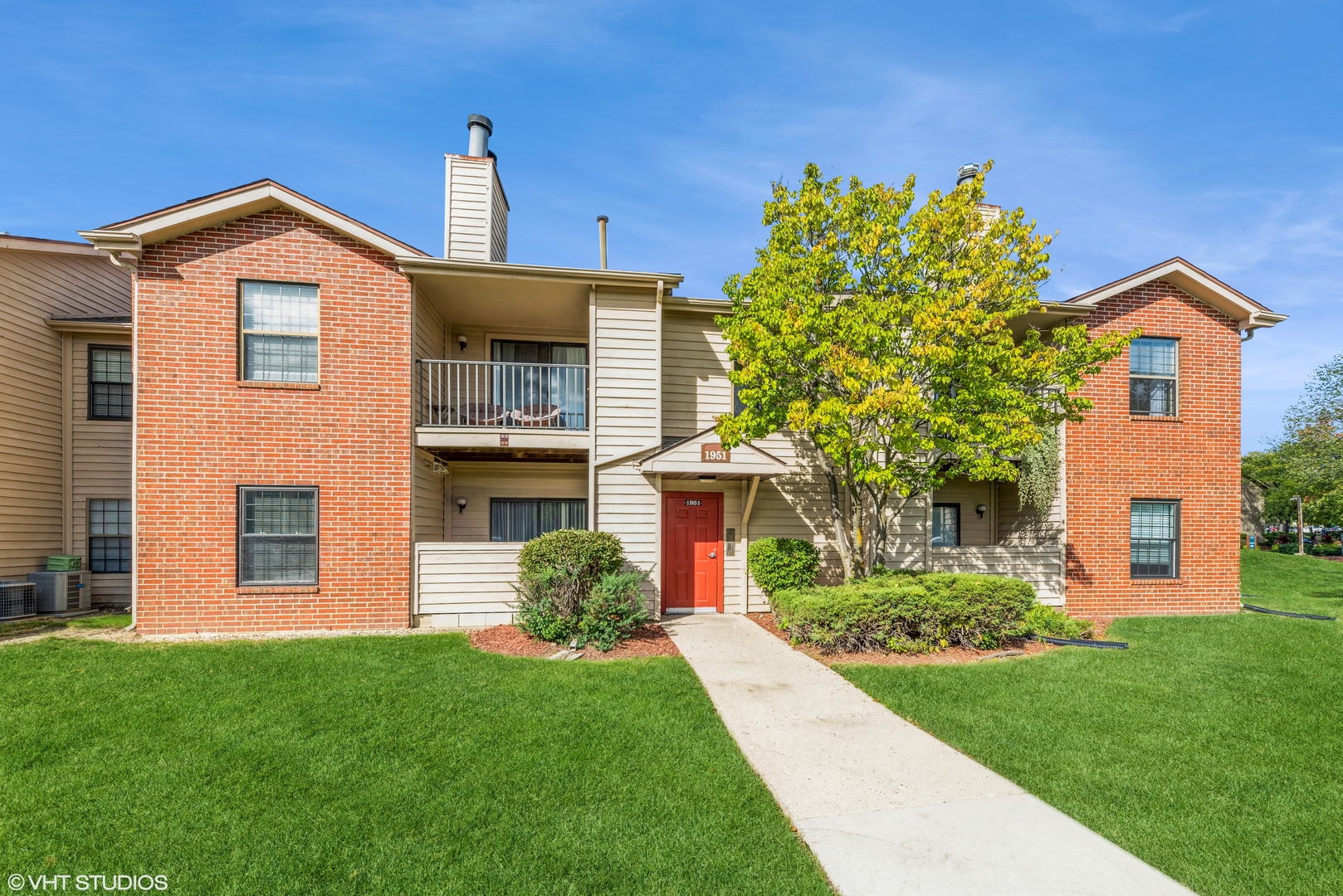 1951 North Hicks Road, Unit 210 Palatine, IL 60074 - Photo 1 of 1 a front view of a house with a yard
