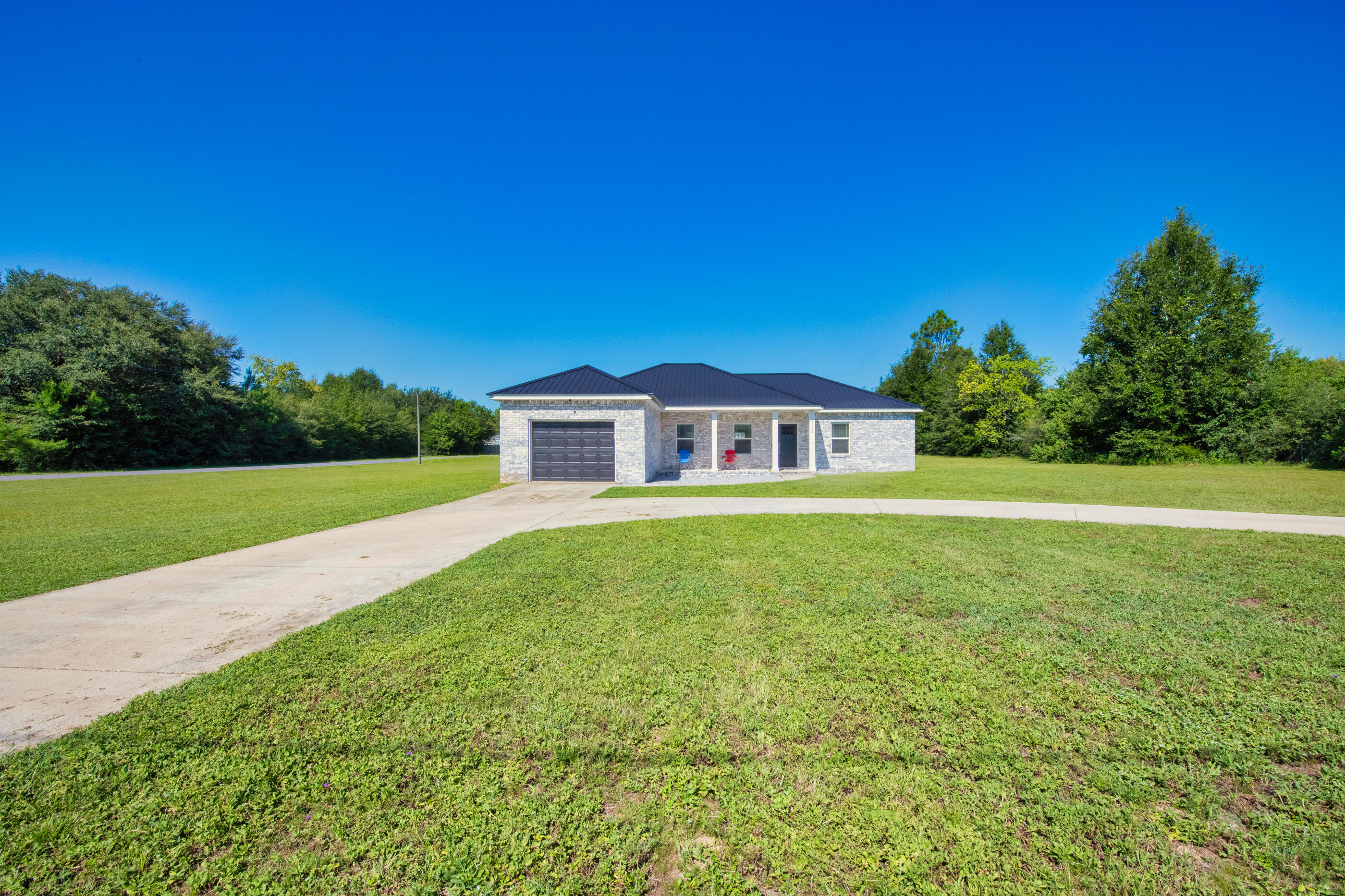 6116 Robin Road Crestview, FL 32539 - Photo 2 of 24 a yellow house with garden in front of it