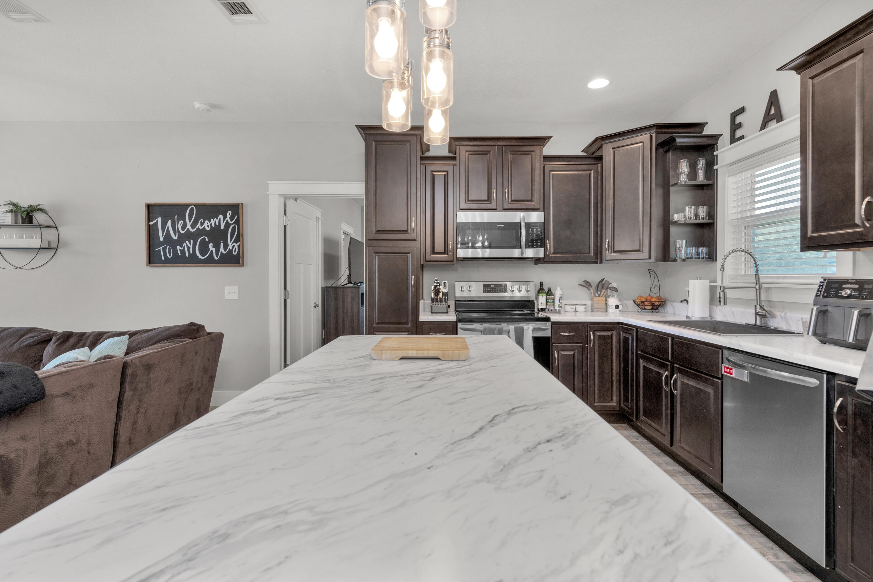 6116 Robin Road Crestview, FL 32539 - Photo 10 of 24 a large kitchen with stainless steel appliances kitchen island granite countertop a sink stove and refrigerator