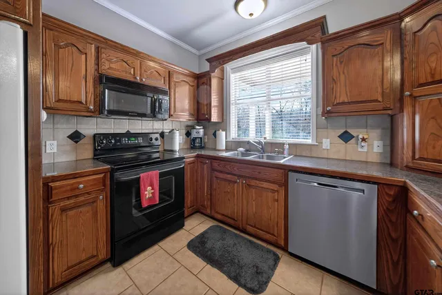 a kitchen with stainless steel appliances granite countertop a table chairs and a refrigerator