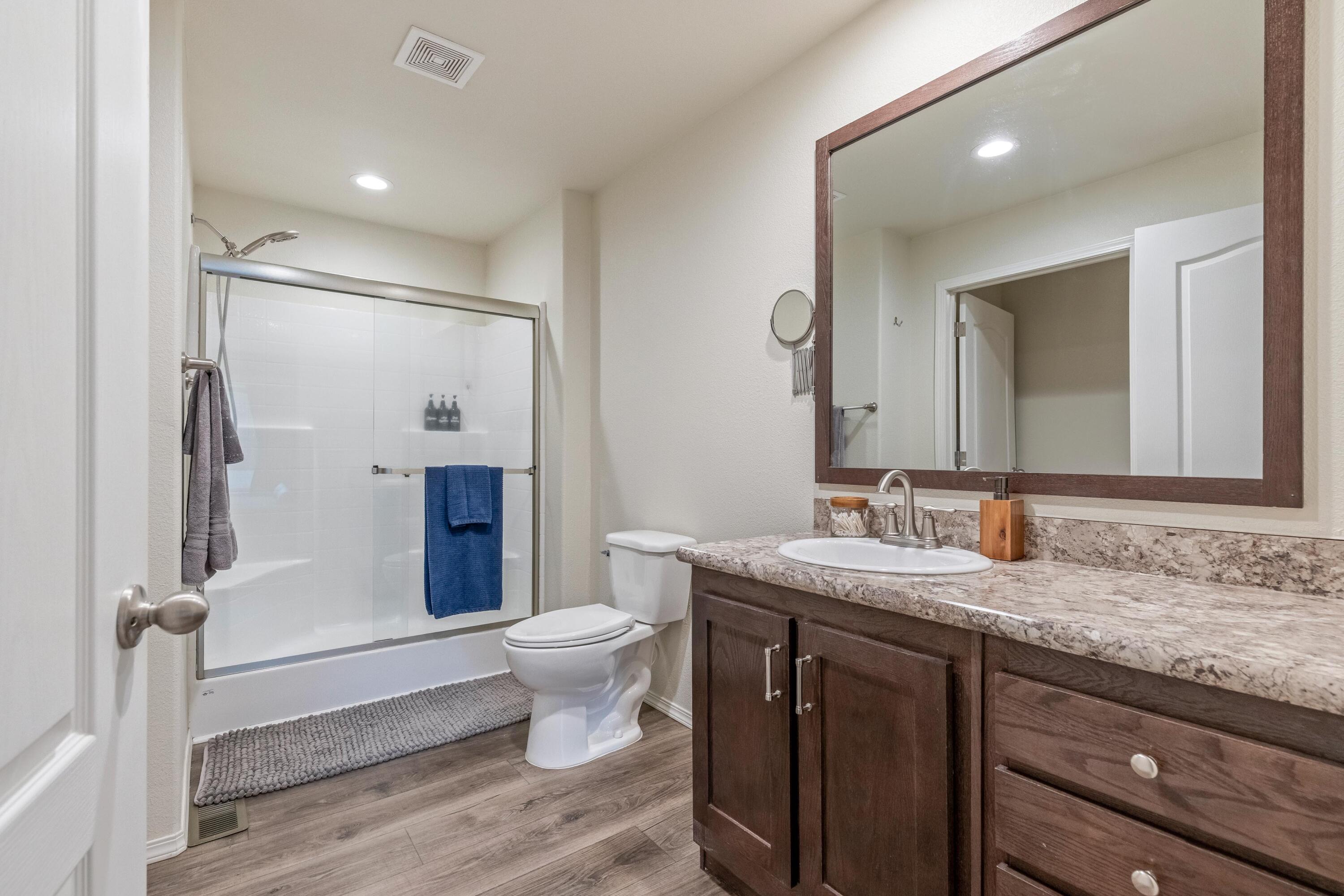 55823 Snow Goose Road Bend, OR 97707 - Photo 15 of 36 a bathroom with a granite countertop sink toilet mirror and shower