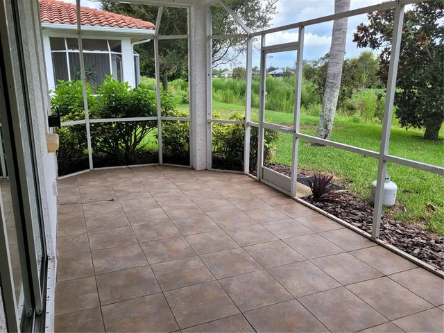 a view of a garden with a chair and a yard with potted plants
