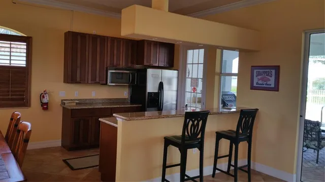 a kitchen with stainless steel appliances a table chairs and a refrigerator