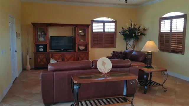a living room with furniture a flat screen tv and a large window