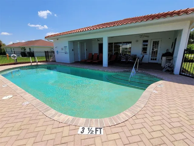 a view of a house with a swimming pool and a yard