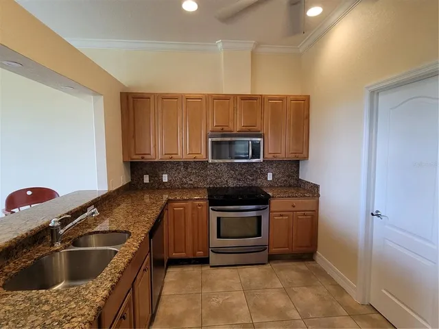 a kitchen with granite countertop a sink and stainless steel appliances