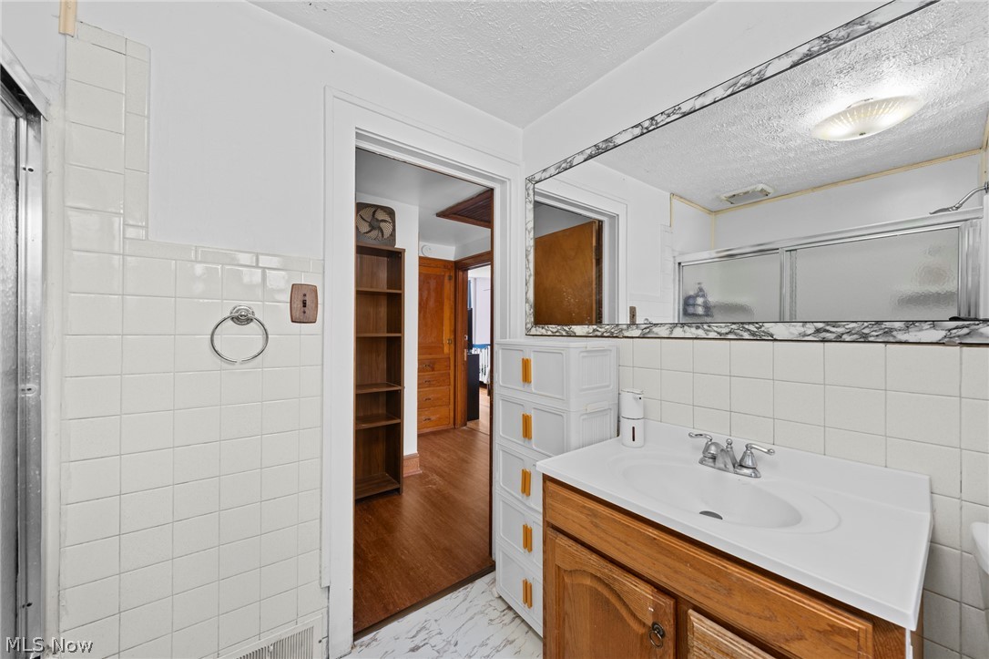 819 Keeney Street Akron, OH 44310 - Photo 20 of 24 Bathroom with a wood-finish vanity, integrated sink, and chrome faucet