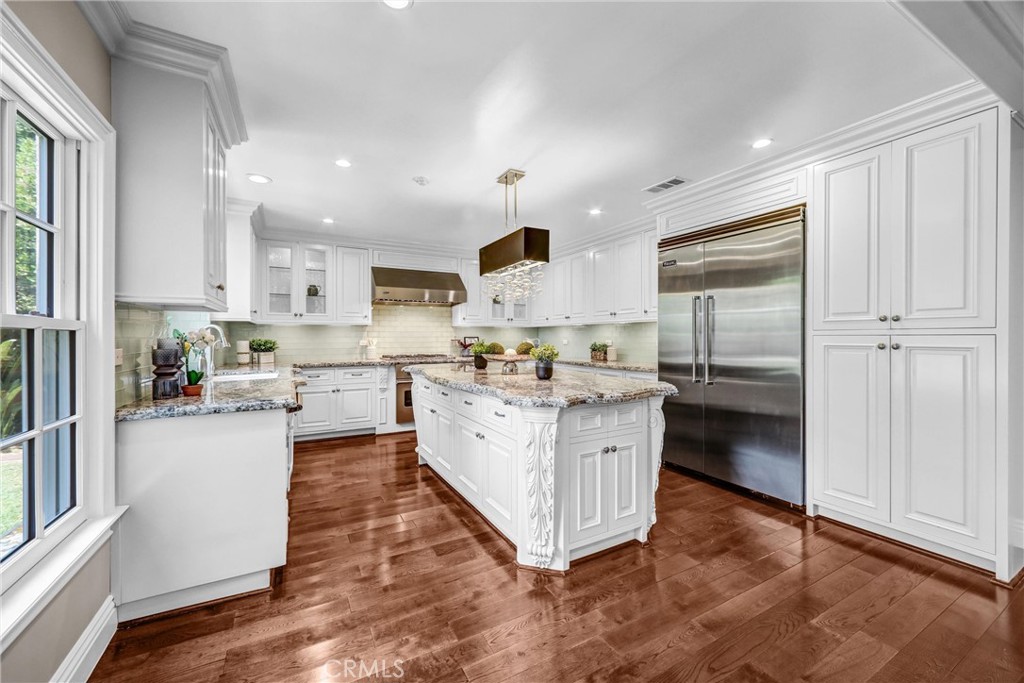 1665 Lorain Road San Marino, CA 91108 - Photo 15 of 45 a kitchen with stainless steel appliances granite countertop a refrigerator a sink dishwasher and white cabinets with wooden floor