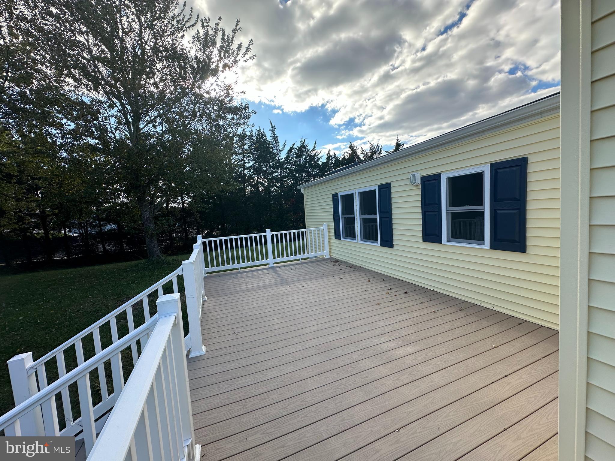 18656 Snowmass Run, Unit 18656 Rehoboth Beach, DE 19971 - Photo 4 of 14 a balcony with wooden floor and trees in the back
