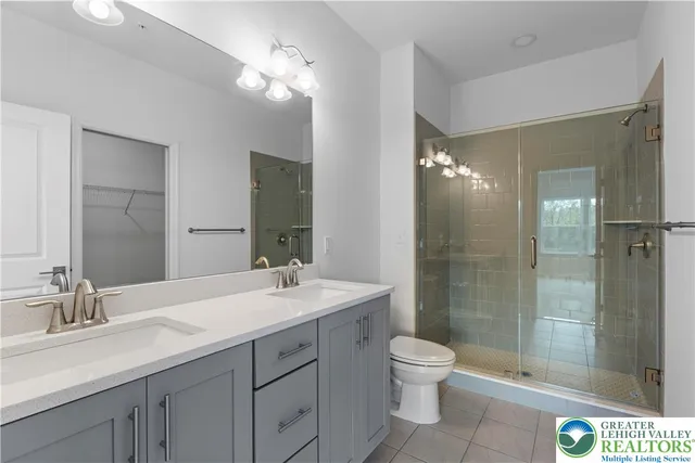 a bathroom with a double vanity sink toilet and shower