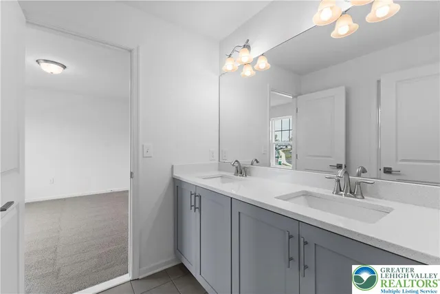 a bathroom with a sink a light fixture and a mirror