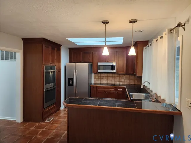 a kitchen with stainless steel appliances granite countertop a refrigerator and a stove