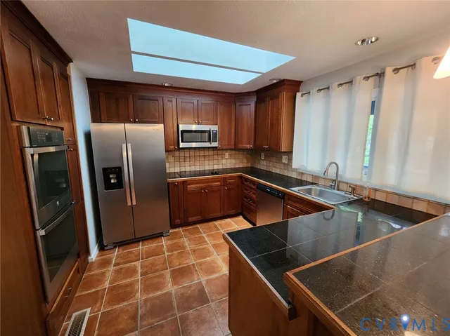 a kitchen with stainless steel appliances a sink stove and refrigerator