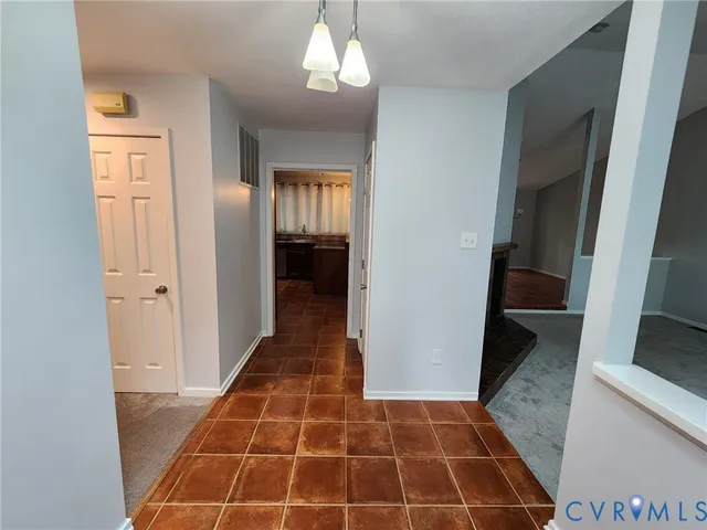 a view of a hallway with wooden floor and a living room