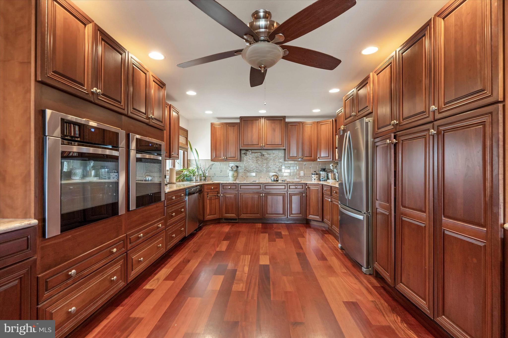 10 Pilot Point, Unit 10B Lewes, DE 19958 - Photo 11 of 38 a large kitchen with stainless steel appliances granite countertop a refrigerator and a wooden floors