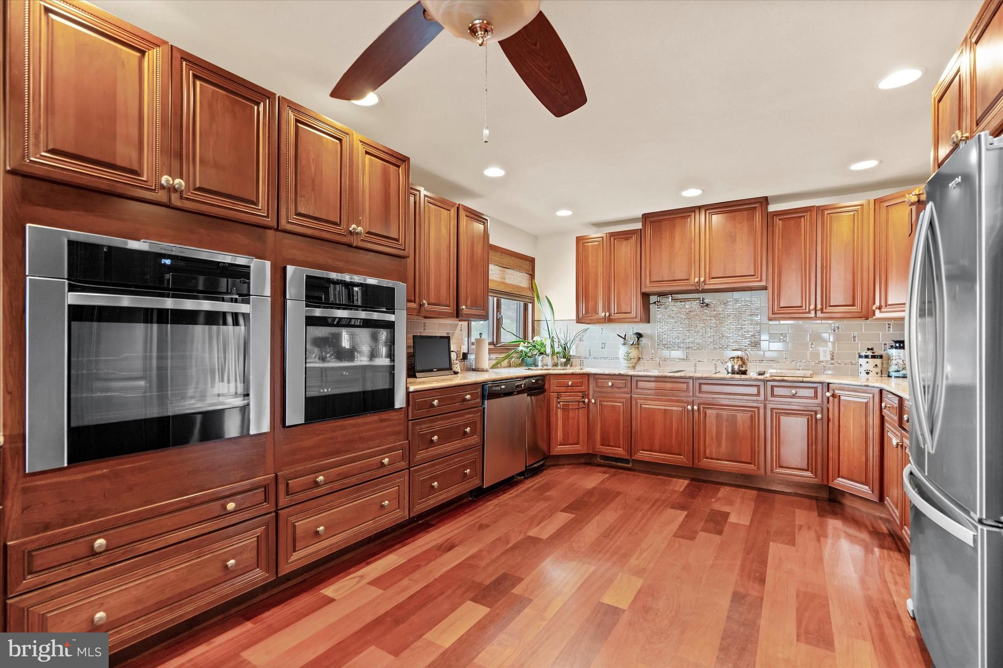 10 Pilot Point, Unit 10B Lewes, DE 19958 - Photo 12 of 38 a kitchen with granite countertop wooden cabinets stainless steel appliances and a window