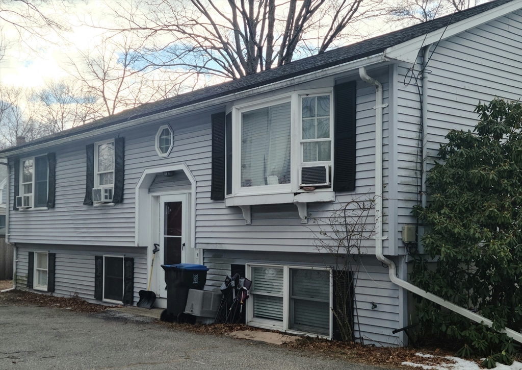 a view of a house with a yard and large tree