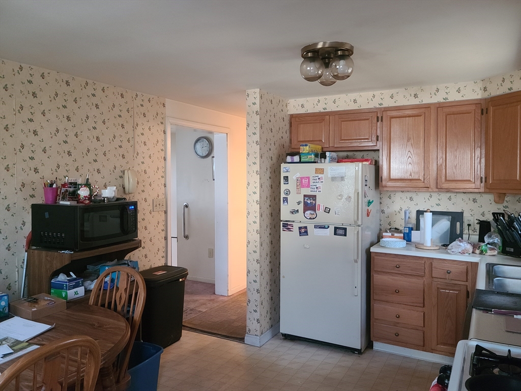 17 Harvard Street Natick, MA 01760 - Photo 6 of 12 a kitchen with a refrigerator and a stove top oven