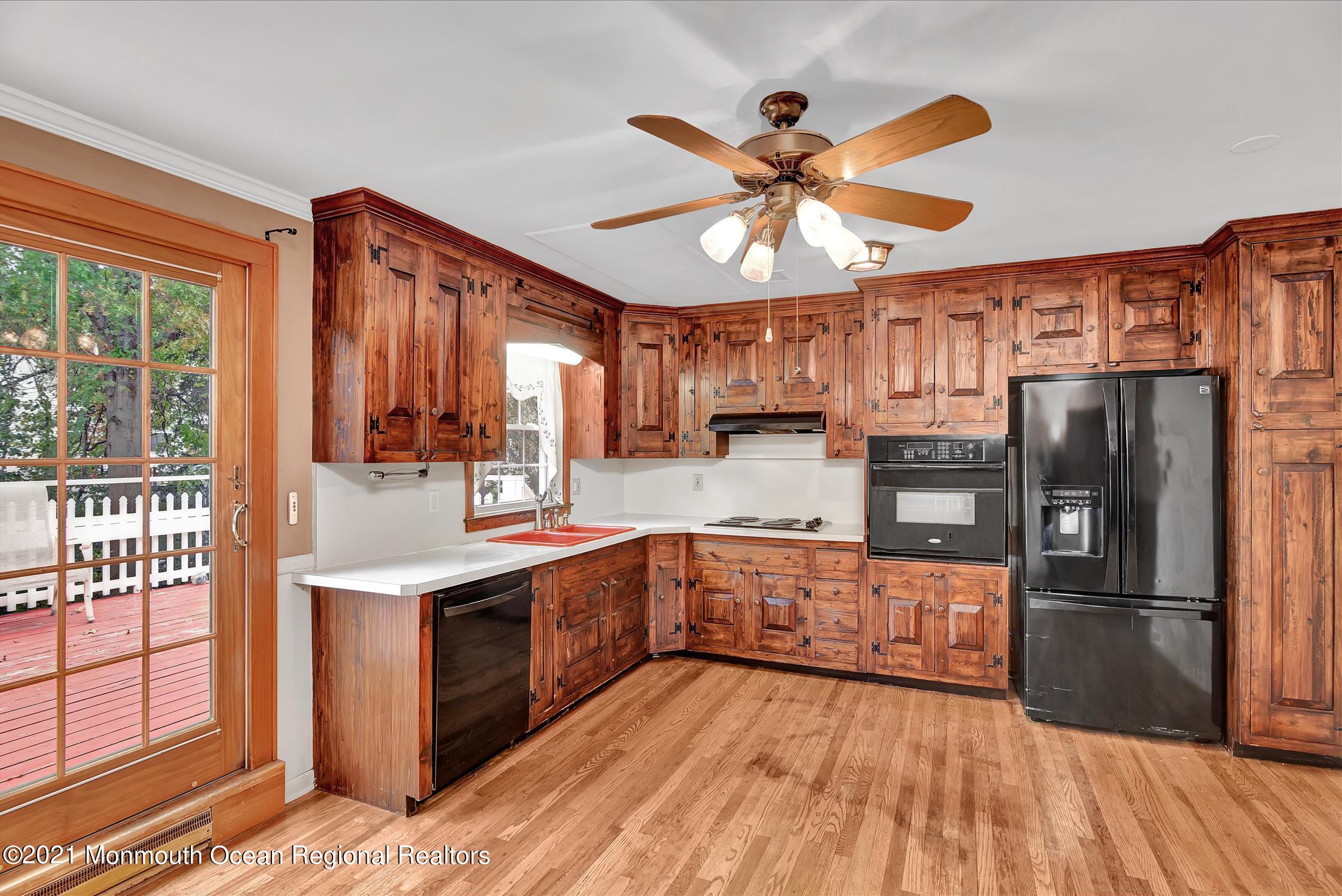 149 Crine Road Morganville, NJ 07751 - Photo 2 of 28 a kitchen with stainless steel appliances a sink cabinets and wooden floor