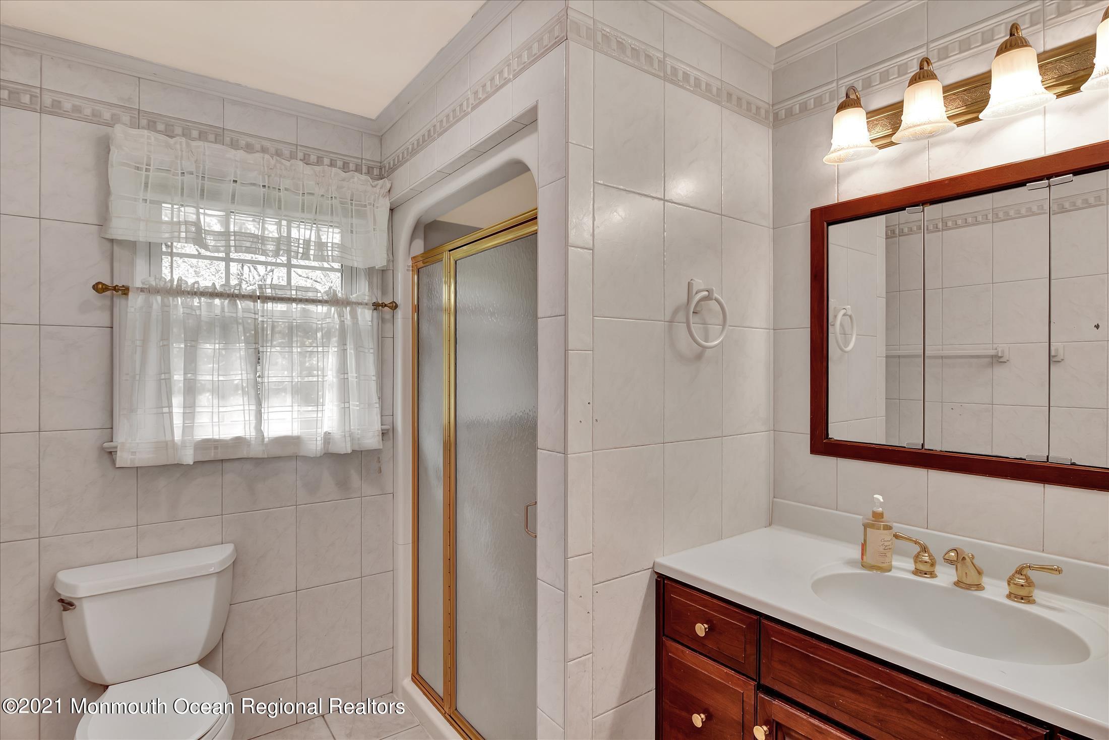 149 Crine Road Morganville, NJ 07751 - Photo 22 of 28 a bathroom with a sink a toilet and shower