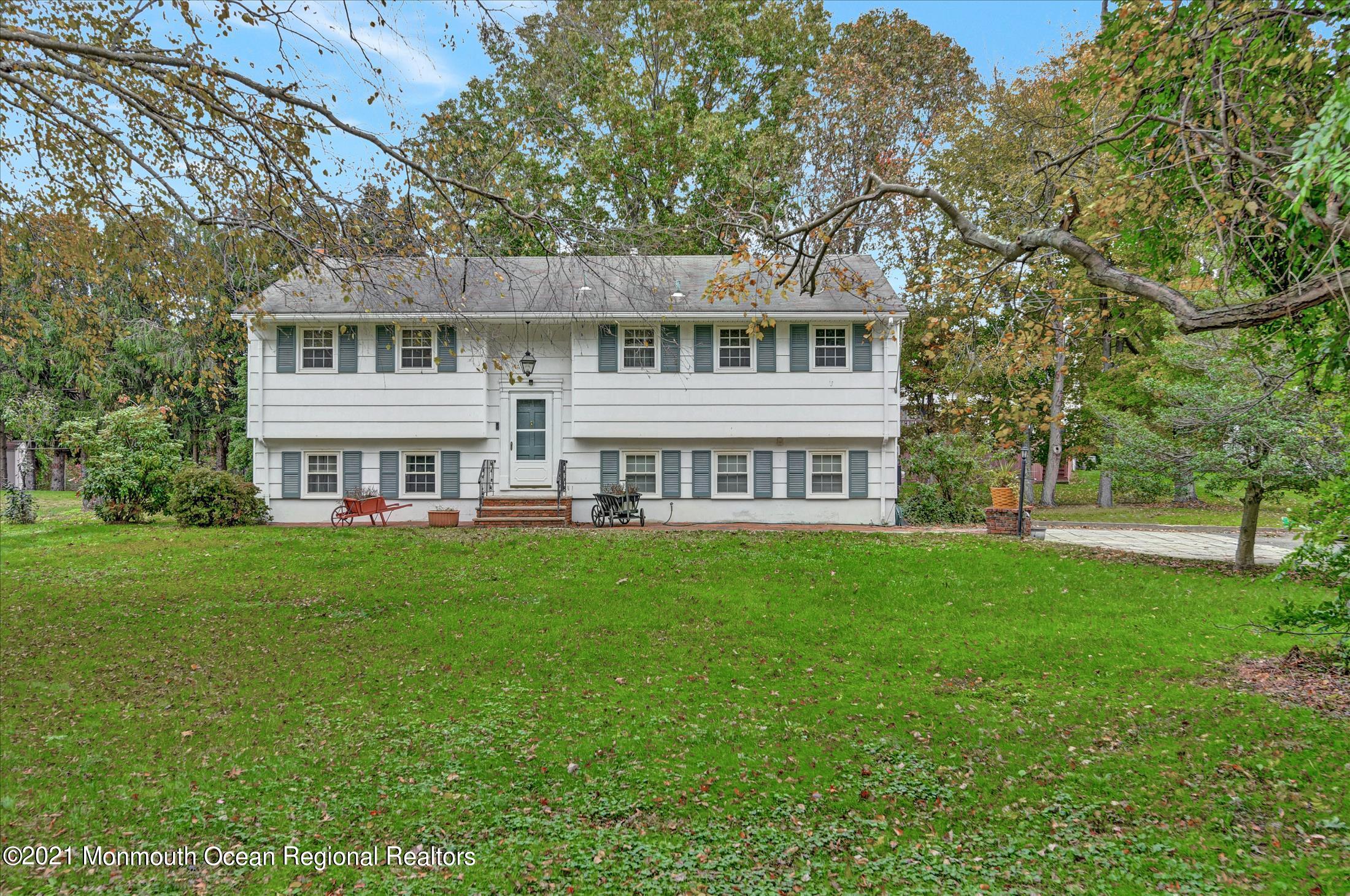 149 Crine Road Morganville, NJ 07751 - Photo 3 of 28 a view of a house with a big yard and large trees