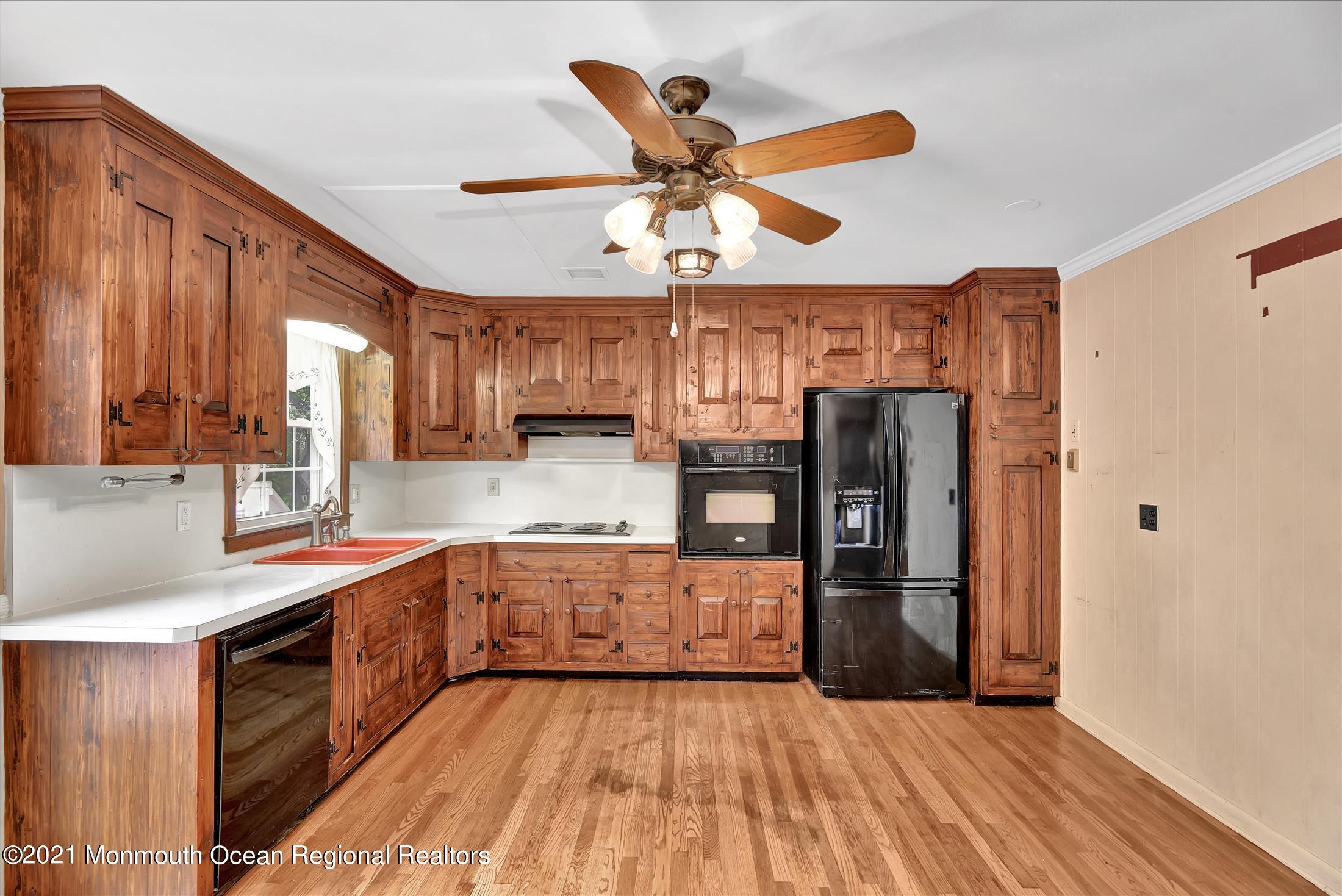 149 Crine Road Morganville, NJ 07751 - Photo 7 of 28 a kitchen with stainless steel appliances a sink cabinets and wooden floor