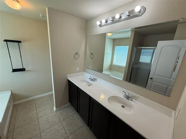 a bathroom with a double vanity sink and mirror