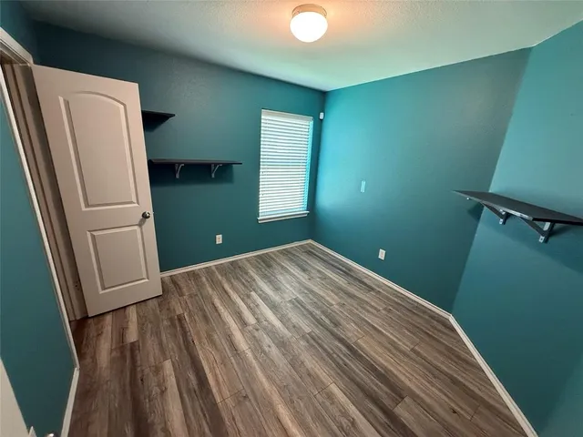 a view of a room with wooden floor and cabinets
