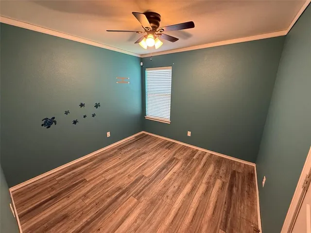 a view of a room with a ceiling fan and a window