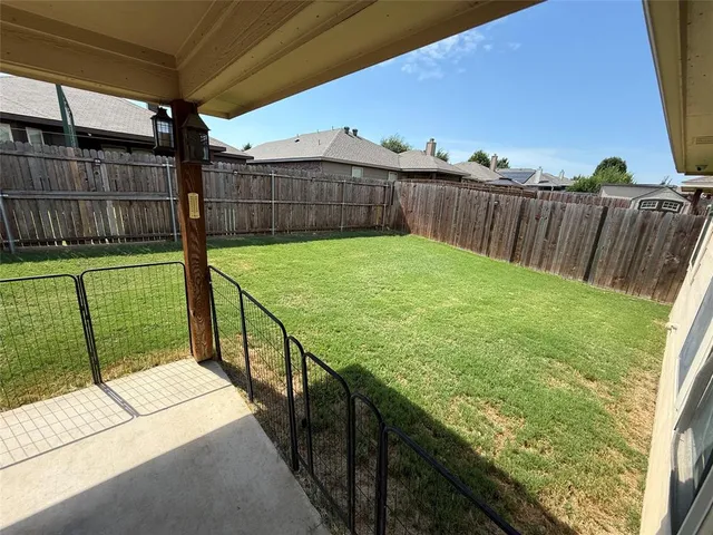 a view of a backyard with wooden fence