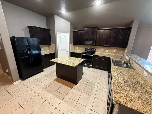 a kitchen with stainless steel appliances a refrigerator and a stove top oven