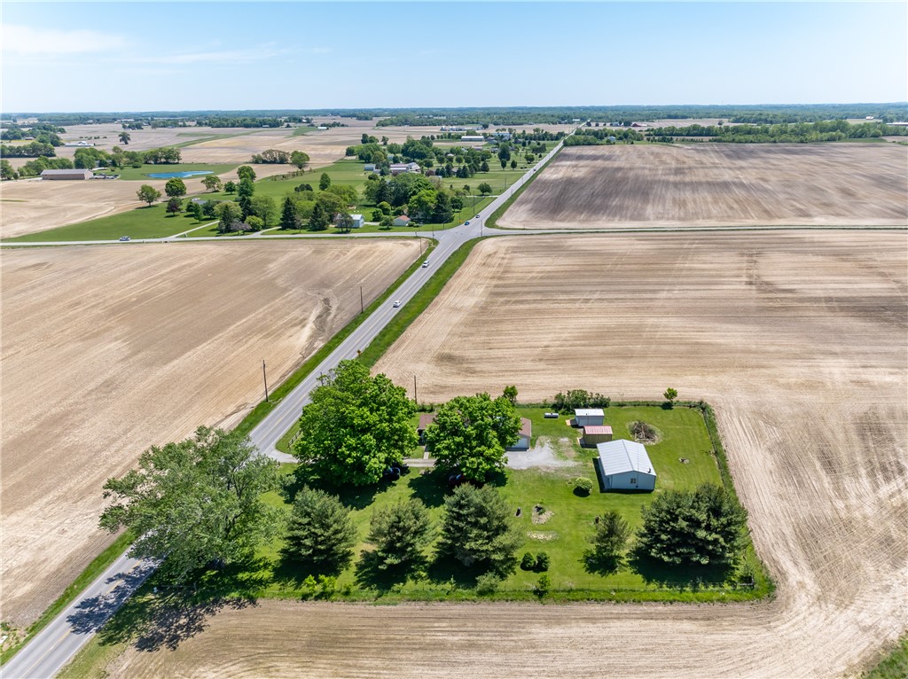 1217 Jasper Road Xenia, OH 45385 - Photo 7 of 62 An aerial view showcases a vast rural landscape with agricultural fields, connecting roads, and distant structures.