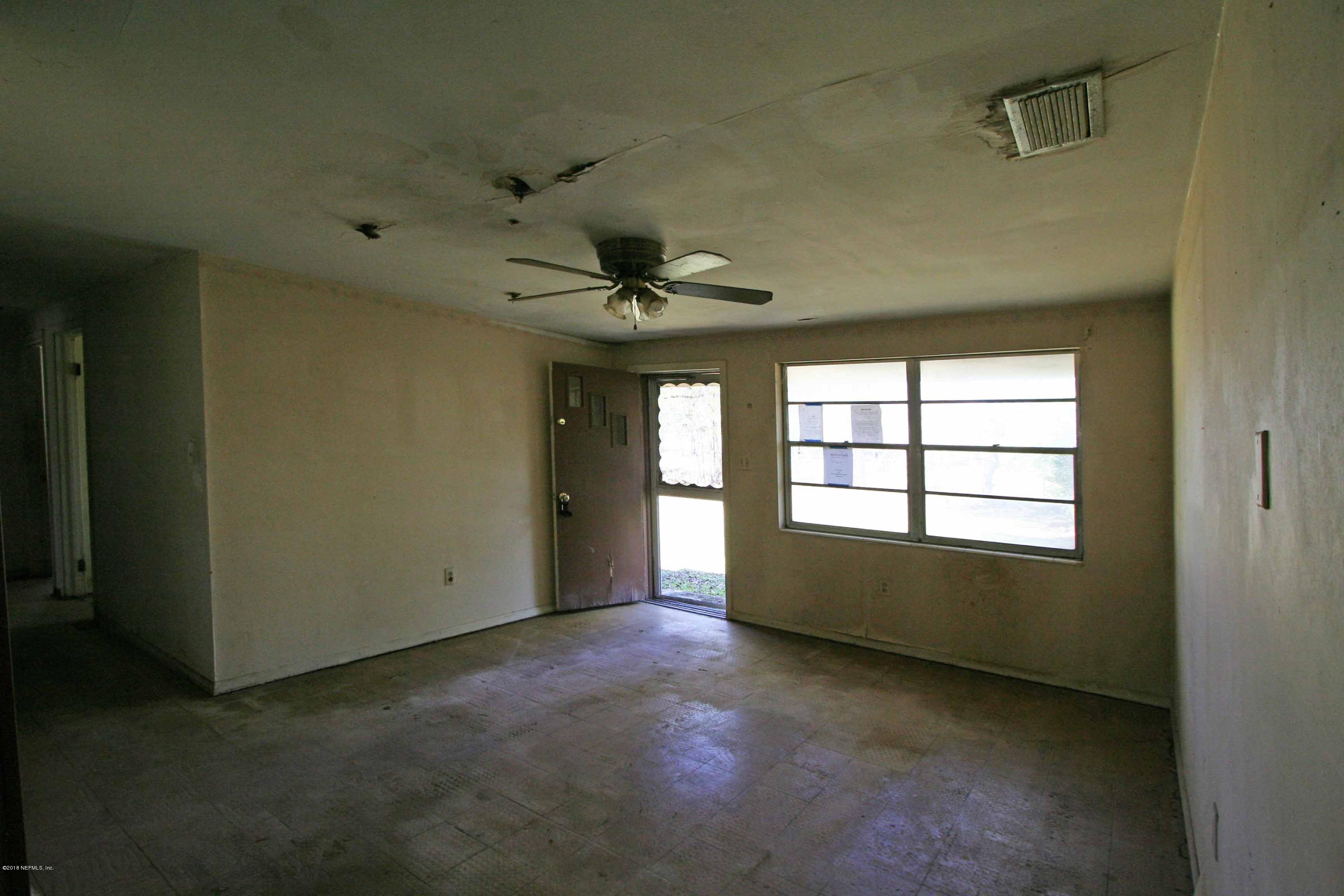 5569 Long Branch Road Jacksonville, FL 32234 - Photo 4 of 9 an empty room with a windows and ceiling fan