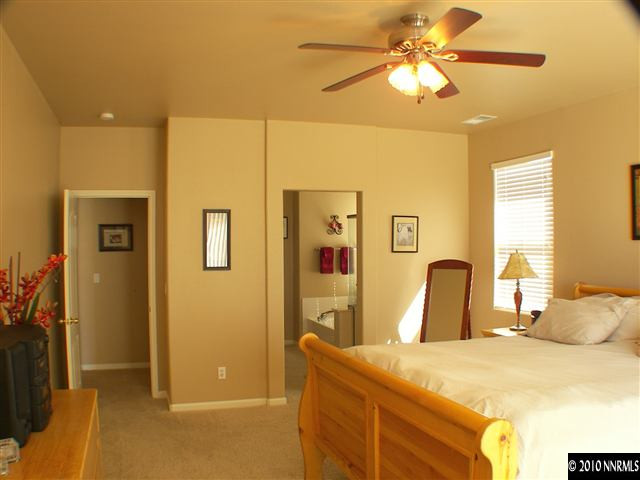 10799 Stone Hollow Drive Reno, NV 89521 - Photo 5 of 9 a bedroom with a bed and a chandelier