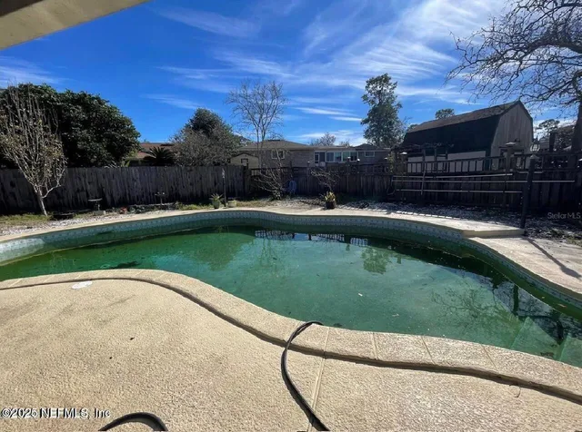a view of a swimming pool with a yard