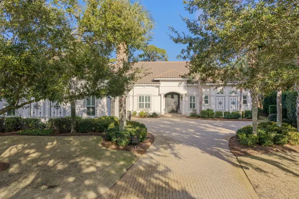 a view of a white house with a yard and plants