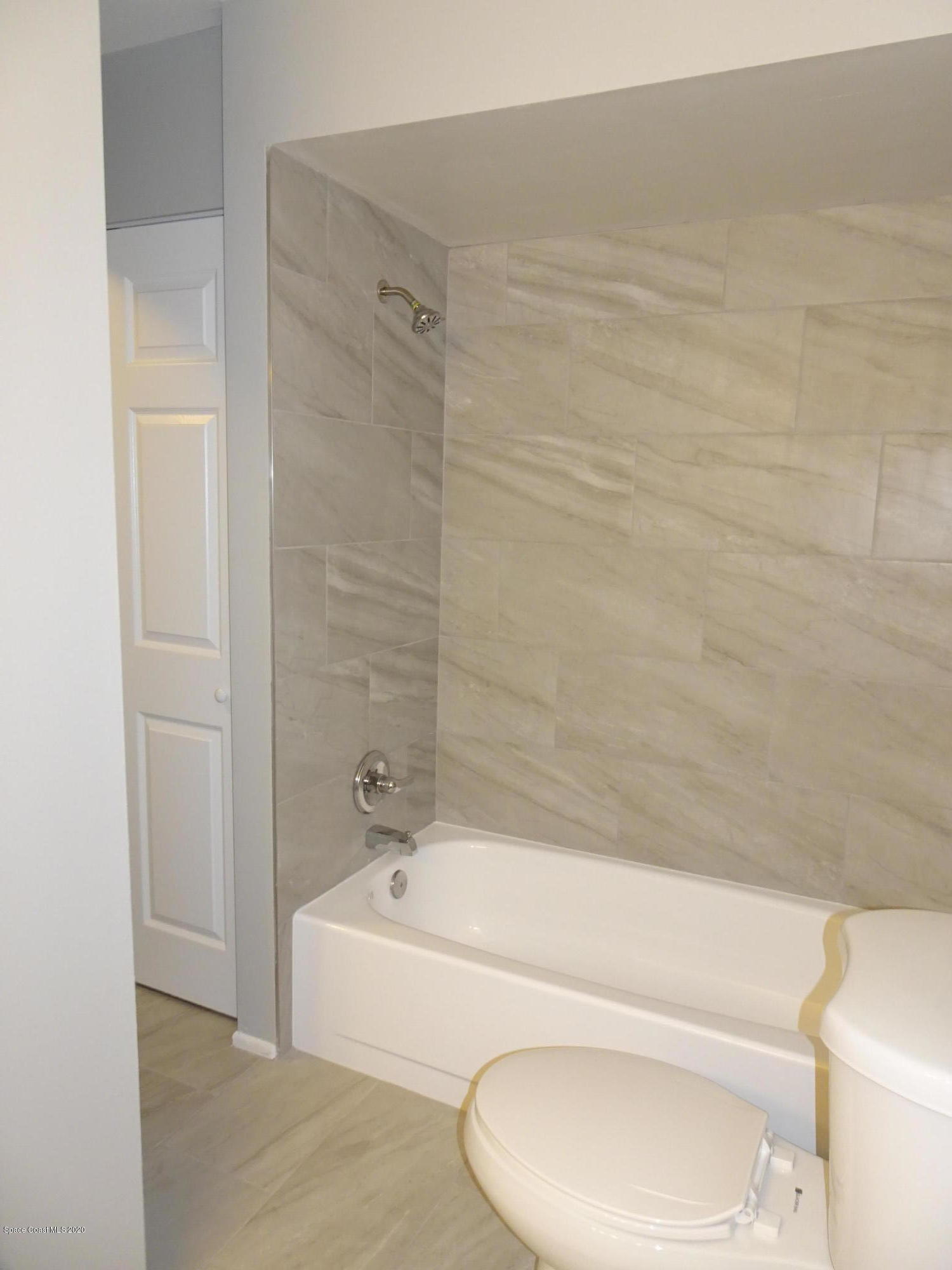 4875 Sisson Road Titusville, FL 32780 - Photo 9 of 14 a bathroom with a bathtub and a toilet