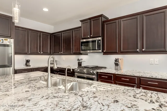a kitchen with stainless steel appliances granite countertop a sink stove and microwave