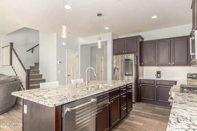 a kitchen with stainless steel appliances granite countertop a sink stove and refrigerator