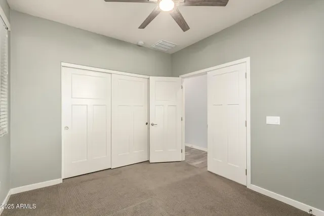 an empty room with a ceiling fan and painted walls