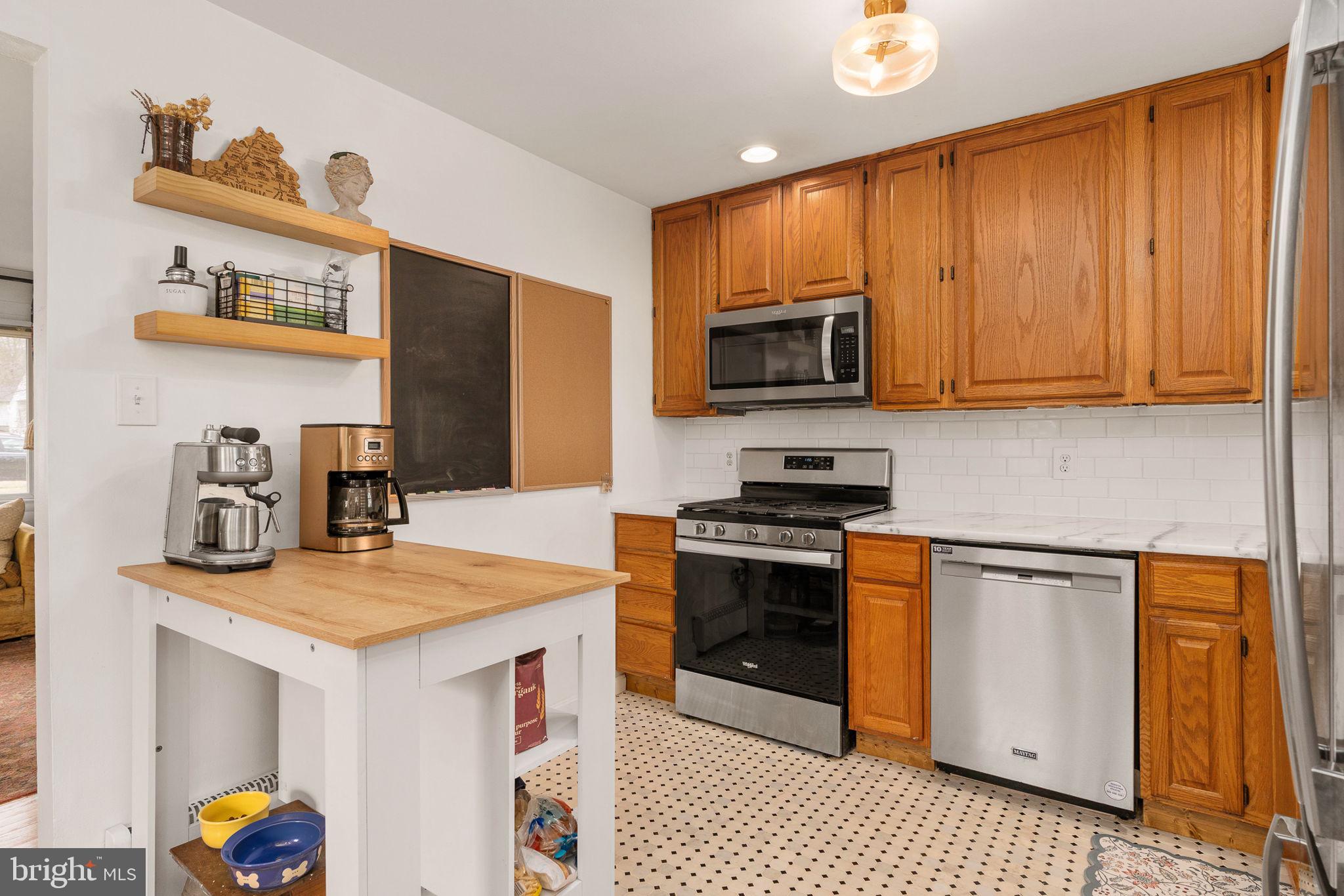 6714 Ruskin Street Springfield, VA 22150 - Photo 21 of 63 a kitchen with stainless steel appliances granite countertop a stove a sink dishwasher and a microwave with wooden floor
