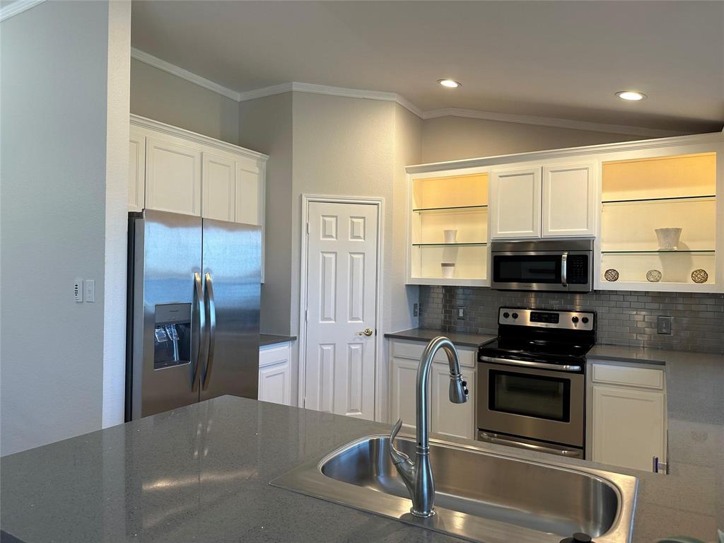1882 Signal Ridge Place, Unit 1882 Rockwall, TX 75032 - Photo 6 of 19 a kitchen with stainless steel appliances granite countertop a refrigerator and a stove
