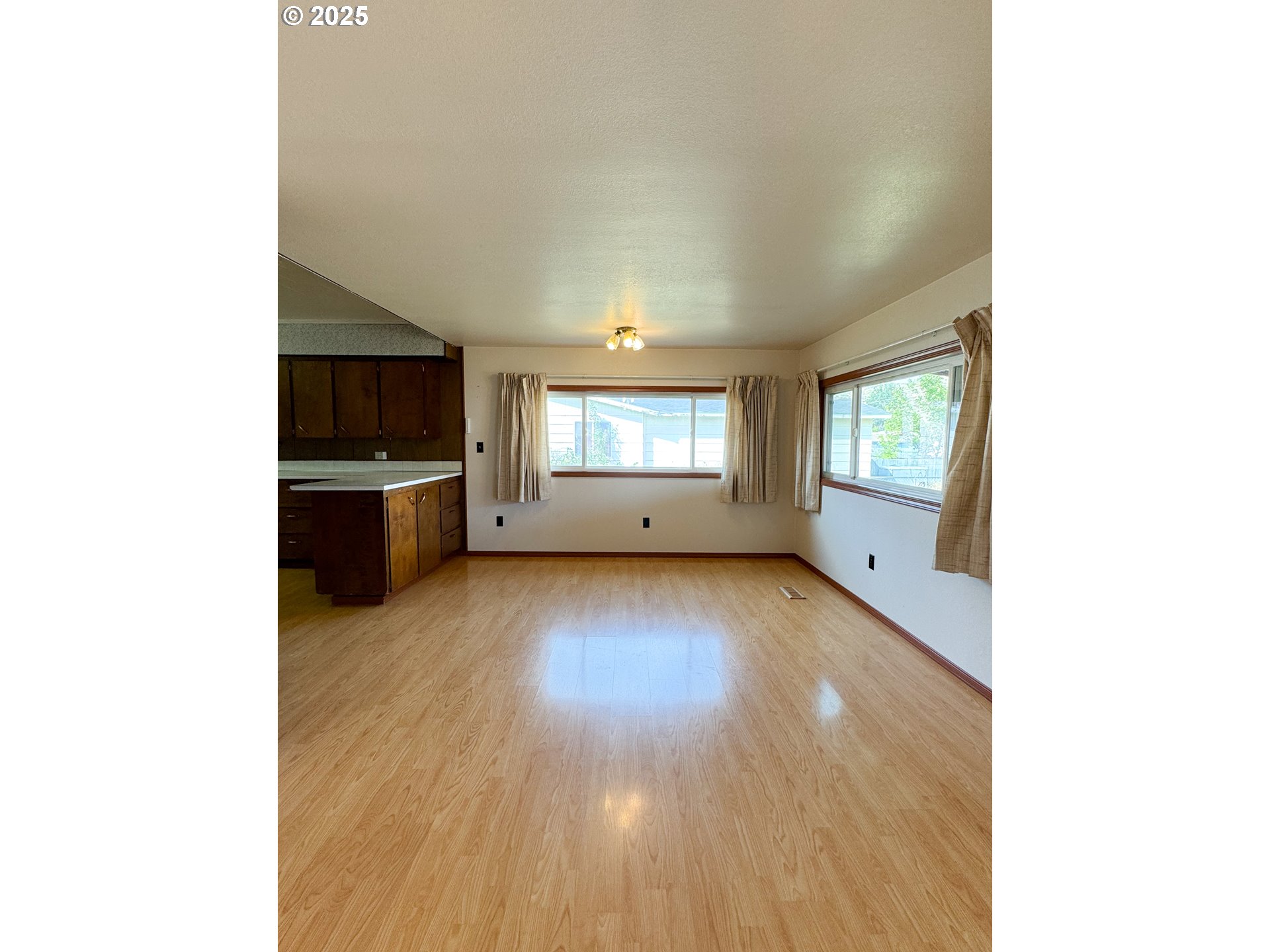 1050 Elm Street Baker City, OR 97814 - Photo 10 of 28 a view of an empty room with a window and a kitchen